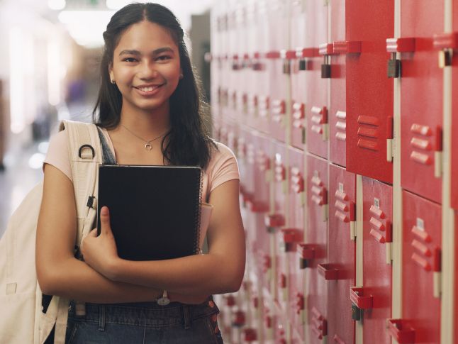  Girl standing in front of locker holding books