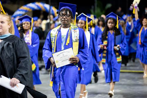 Student walking with diploma after graduation