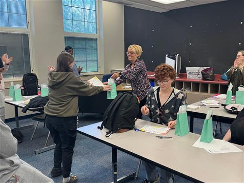 woman handing a gift bag to a student
