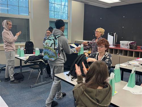 woman handing a gift bag to a student
