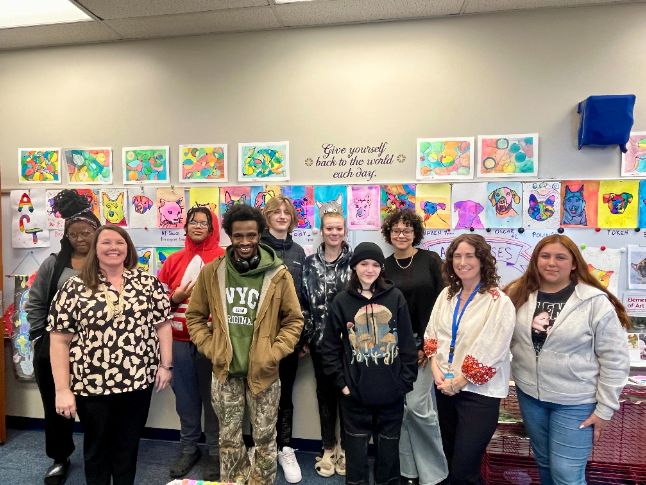 Forest Park art students stand in front of their pet portraits.