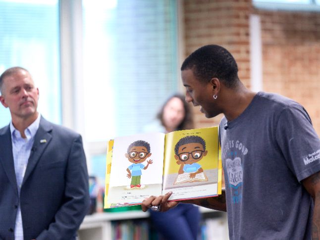  Malcolm Mitchell reads a book in the Lincoln Terrace library.