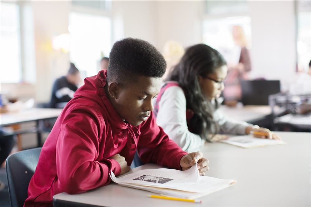 Students sit at their desk and work on an assignment.