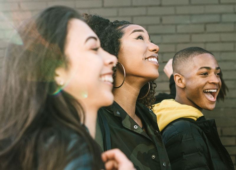 3 high school students walking together and smiling